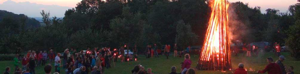 Sonnwendfeuer auf dem Köpfle mit vielen Menschen um das Feuer